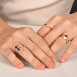 Details von goldfarbenen Ringen mit smaragdgrünen und blauen Zirkonia Steinen