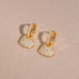 Close-up of heart pendant hoop earrings with gold plating and paved cubic zirconia