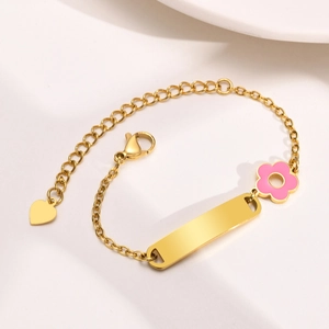 Detail of gold stainless steel bracelet featuring pink flower and engravable blank plate