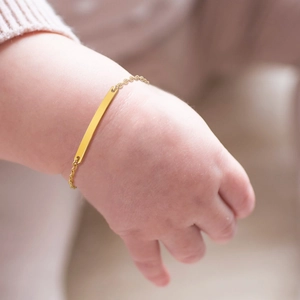 Macro detail of baby identification bracelet in gold finish with customizable blank bar