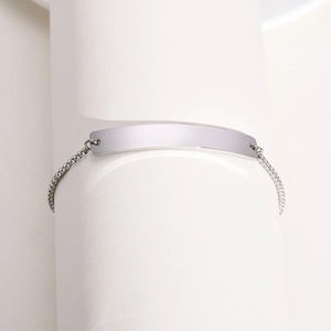 Close-up of polished stainless steel ID bracelet with adjustable slider and woven chain