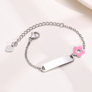 Detail of adjustable stainless steel bracelet with pink enamel flower and engravable plate