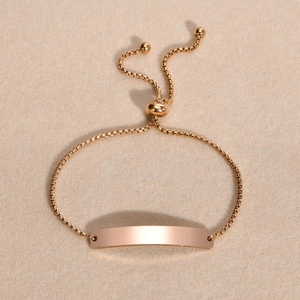 Macro shot of rose gold adjustable box chain bracelet with a blank curved plate for DIY