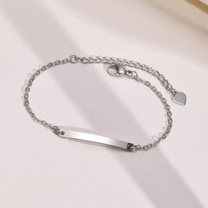 Detailed view of polished stainless steel bar bracelet with adjustable chain and heart charm