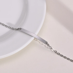 Close-up of a sleek stainless steel bar bracelet with minimalist silver link chain