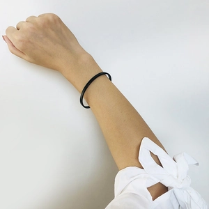 Close-up of minimalist 5mm black matte stainless steel cuff bracelet on a female wrist