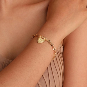 Detail of 14K gold plated heart pendant with letter M on a stainless steel lip chain