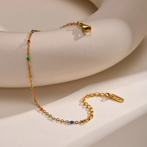 Detailed macro view of a gold chain with colorful enamel dots and K18 lobster clasp