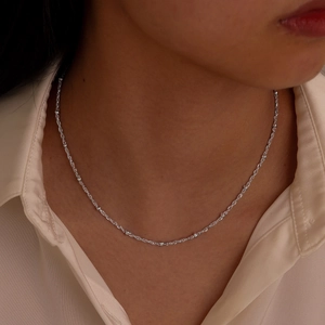 Minimalist silver stainless steel bead chain necklace worn as a refined choker