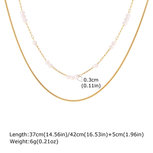 Detailed view of gold double layer necklace with small pearls and snake chain