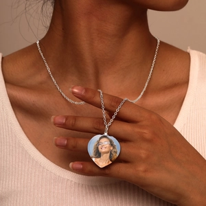 Detalle del collar con colgante de corazón y foto personalizada en el cuello de modelo