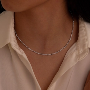 Close-up of minimalist stainless steel station chain necklace on model neck