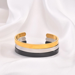 Polished stainless steel cuff bracelets in gold, silver, and black on white satin