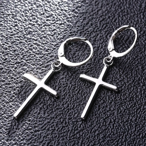 Vue détaillée des boucles d'oreilles S925 croix argentée sur fond noir texturé