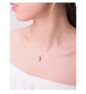 Primo piano di una collana con ciondolo a gatto in argento satinato su una modella