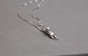 Dettaglio macro del ciondolo a gatto 3D in argento opaco con catena a maglia box