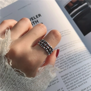Close-up of vintage wide silver braided ring styled with a white knitted sweater