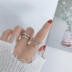 Anillo vintage de plata con nudo y colgante de cara sonriente con uñas rojas