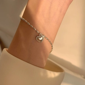 Versilbertes Herz-Armband mit Reiskörnern an einem Handgelenk für einen minimalistischen Look