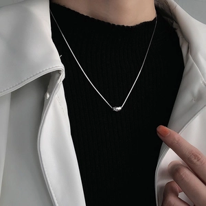 Collana minimalista in argento S925 con ciondolo a fagiolo indossata su maglia nera