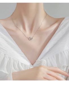 Close-up of s925 silver crescent moon necklace with glowing moonstone on model