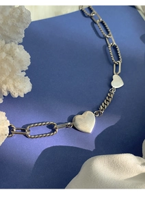 Détail de pendentifs cœur en argent s925 sur des chaînes à maillons mélangés