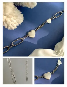 Détail macro du pendentif cœur argenté S925 et des maillons de chaîne épais vintage