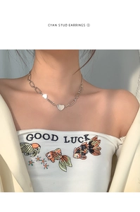 Gros plan d'un collier avec pendentif double cœur et grosse chaîne argentée sur modèle