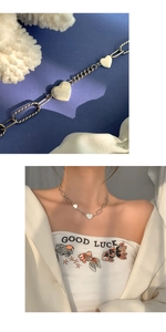 Détails des pendentifs cœur en argent sur un collier à mailles cubaines et ovales