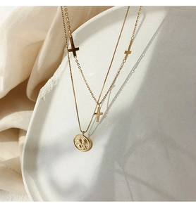 Detalle del collar de capas en plata 925 dorada con cruces y moneda de ángel redonda
