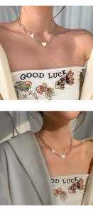 Détail du collier coeur plaqué argent s925 avec chaîne asymétrique et pendentif chance