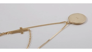 Detalle de collar de plata S925 dorada con discos redondos y colgante de cruz pequeña