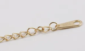 Detalle macro de cadena de plata de ley S925 bañada en oro con grabado de sello de autenticidad