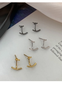 Dettaglio di orecchini geometrici minimalisti S925 nei colori oro, argento e nero