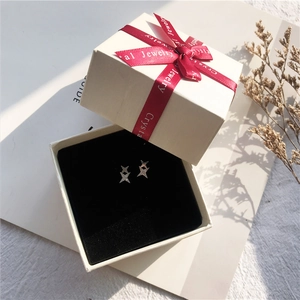 Silver star stud earrings with zircons in a premium white gift box with floral decor