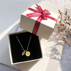 Mini silver necklace with lemon and leaf charms in white gift box with red ribbon