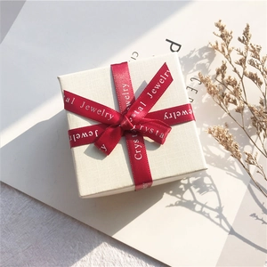 Mini square cream jewelry box with a red ribbon bow and crystal jewelry printing