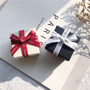 Elegant square jewelry gift boxes in beige and black with silk ribbon bow decoration