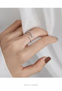Detalle del anillo de plata cruzado con micro circonitas y diseño ajustable