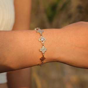 Detail eines Kleeblatt-Armbands mit Zirkon-Mikropflaster an einem Frauenhandgelenk
