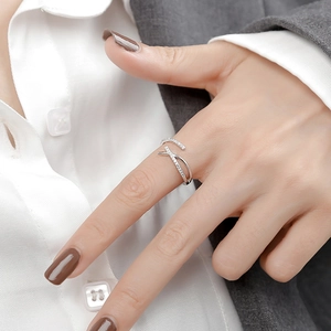 Anillo abierto plateado minimalista con diseño cruzado en X y piedras de circón pavé