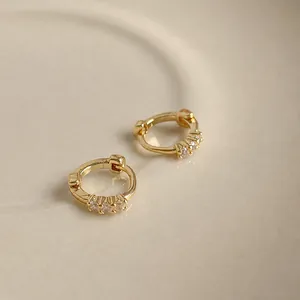 Pendientes de aro dorados minimalistas con tres piedras brillantes y un cierre de click
