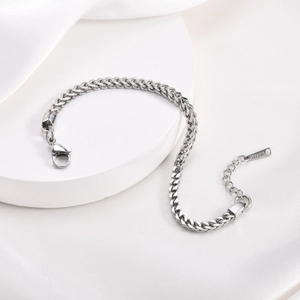 Silver stainless steel box chain bracelet with lobster clasp on white silk background