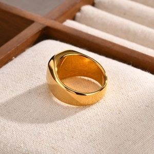 Close-up of golden wide-band stainless steel ring with high-polished mirror finish