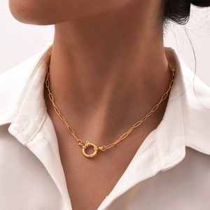 Detail of a gold stainless steel paperclip chain necklace with a round spring clasp
