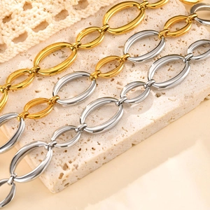 Vue macro de bracelets à gros maillons ovales en acier inoxydable doré et argenté poli