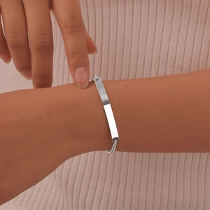 Polished stainless steel rectangular bar bracelet with dainty link chain on wrist