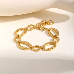 Vue détaillée du gros bracelet à maillons dorés avec fermoir mousqueton et polissage