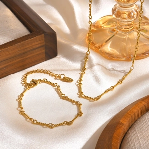 Gold-plated stainless steel rope chain necklace with adjustable clasp on silk background
