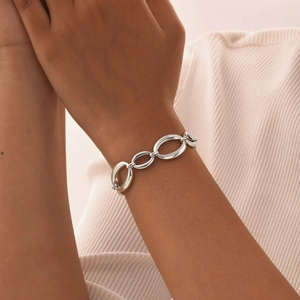 Vue détaillée d'un bracelet à grosses mailles en acier inoxydable poli sur poignet féminin
